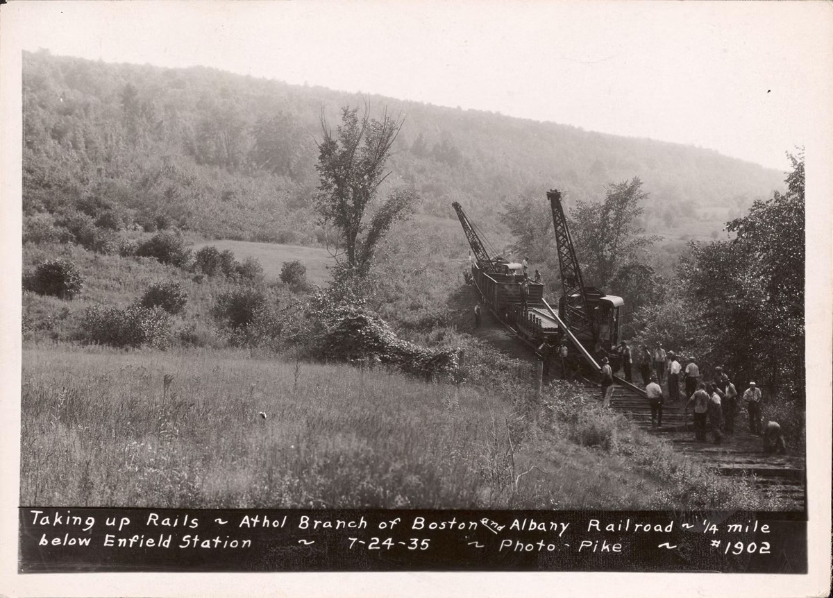Black-and-white 1935 photo of workers taking up the railroad tracks below Enfield Station